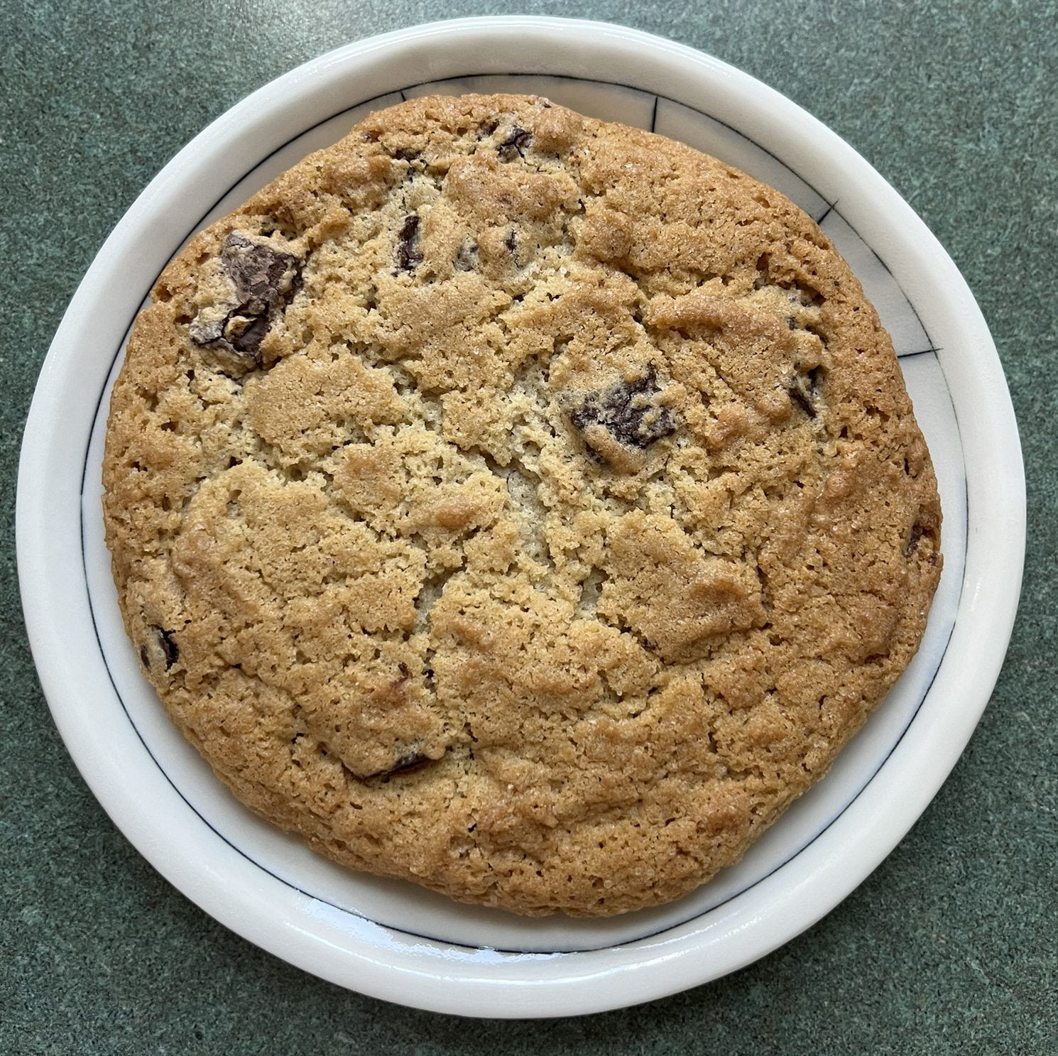 A cookie with a crackly top and some chocolate poking out