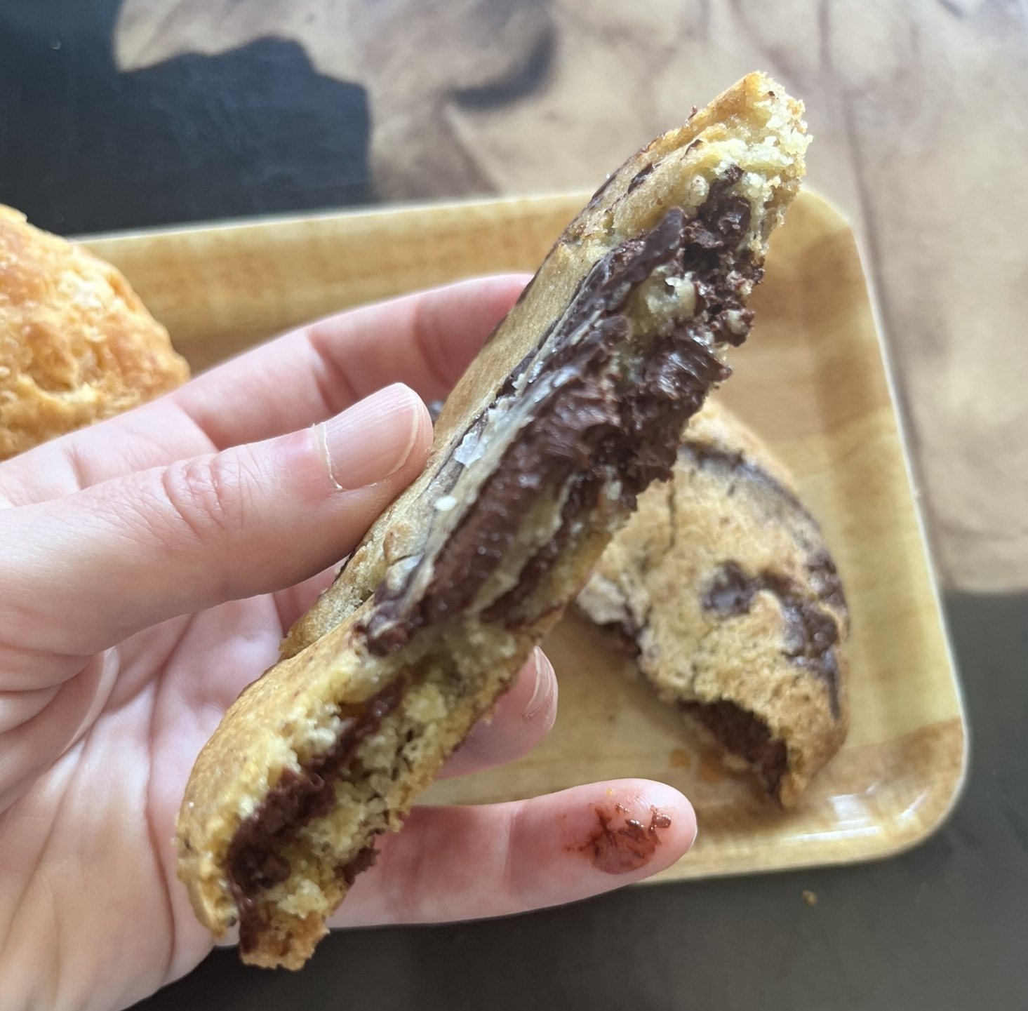 A cross section of the chocolate chip cookie, with large chunks of melty chocolate and flaky salt on top